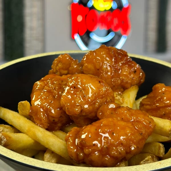 Itokos Grill's sweet and sour chicken bites with french fries in a black bowl.